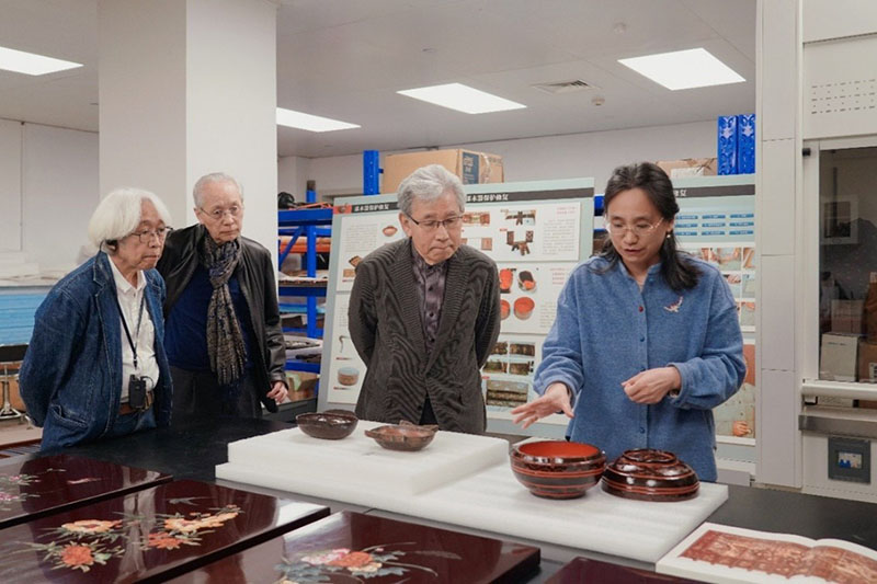 日本傳統工藝從業者訪華團在湖北省博物館漆器修復室聽取有關出土古代漆器的講解。